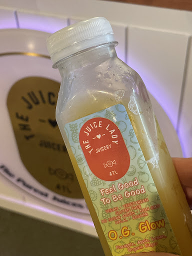 A customer holding an OG Glow juice bottle from The Juice Lady ATL